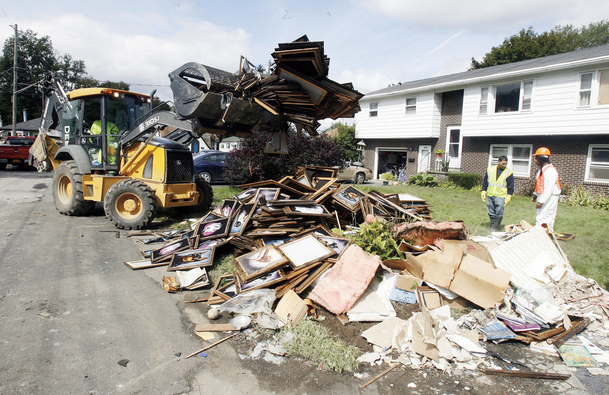 A Vestal DPW crew cleans debris from the front of a home in the Twin Orchards section of Vestal Sept. 16, 2011. ( Seth Harrison / The Journal News )