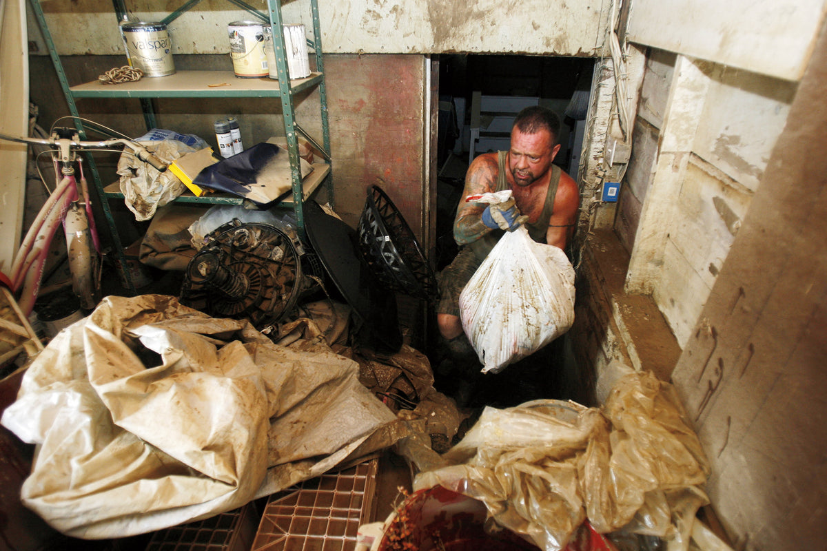 Mark Vosbury removes damaged items and debris from the basement of one of his two rental properties on Conklin Ave. in Conklin Sept. 14, 2011. Vosbury's tenants lost much of their property stored in the basement of the two houses. Vosbury's auto sales company, located adjacent to the two homes, was also damaged by the flood waters. ( Seth Harrison / The Journal News )