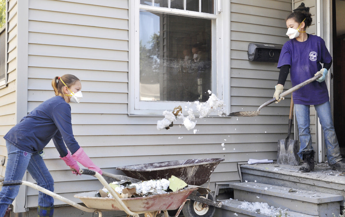 DEBBIE SWARTZ / Staff Photo Kirsten Fuller, left, and Karaleah Scelsia, members of the Twin Orchards Baptist Church youth group, helped cleanup a flooded property on Valley Road in Vestal Sunday.