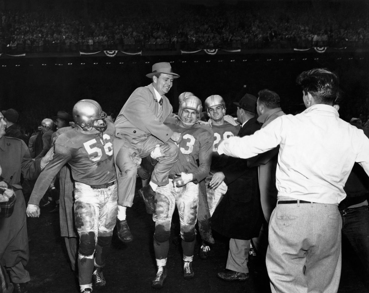  Detroit Lions celebrating on the field at Briggs Stadium after winning the 1953 NFL Championship. Joe Schmidt (#53) and Dick Stanfel (#63) hold coach Buddy Parker. Behind them stands Yale Lary (#28).Courtesy Detroit Historical Society / #2014.003.182