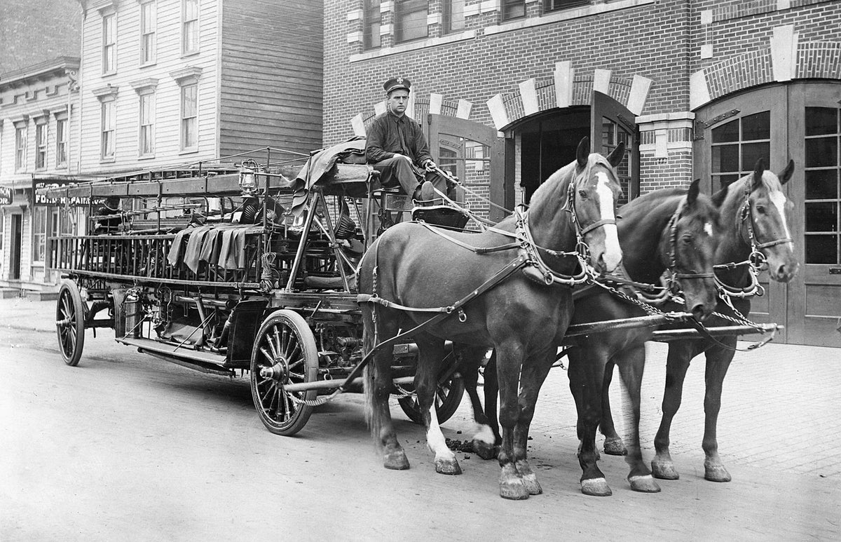 Utica Fire Department's Truck No. 2 in front of the Central Fire Department between 1911 and 1915. The driver is William L Richards.