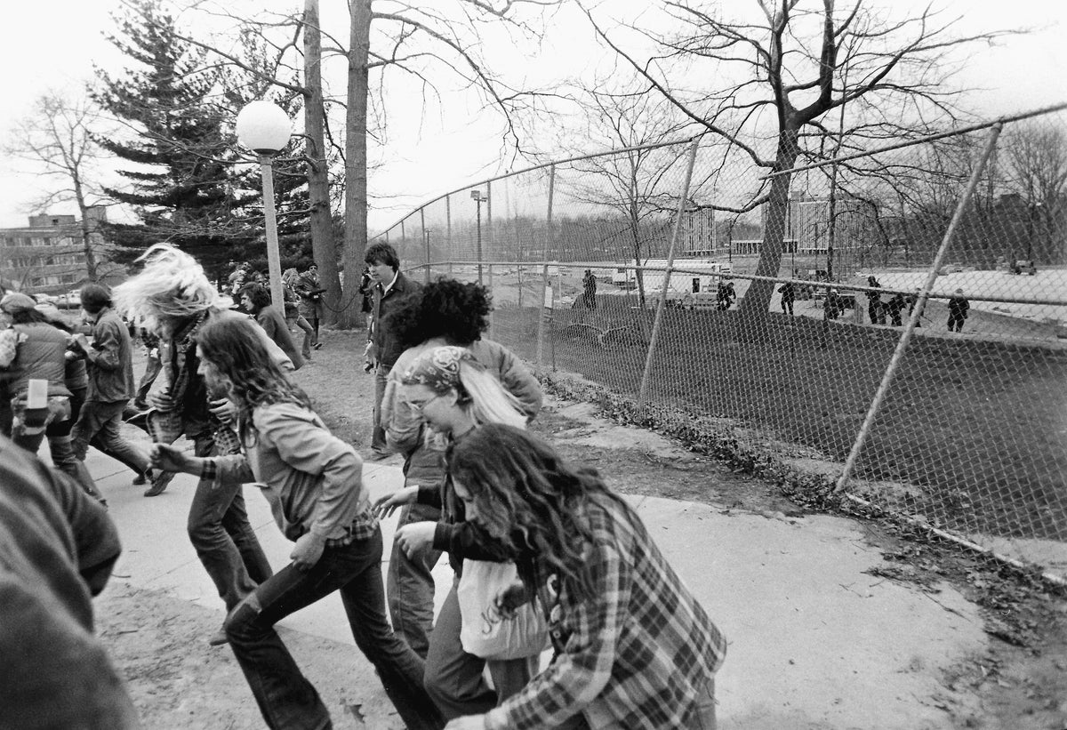 Students run from tear gas after they broke a construction fence near Taylor Hall. Police are in the background, May 4, 1978. Courtesy Akron Beacon Journal