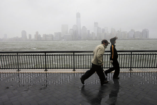 People come out to the Jersey City waterfront where the water levels of the Hudson River reached the seawall due to Hurricane Sandy. Jennifer Brown / The Star-Ledger