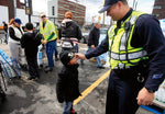 Hoboken Patrolman William Oquendo comforts Amare Griffin, 4, as officers help pass out free ice and water provided by PSE&G. Jennifer Brown / The Star-Ledger