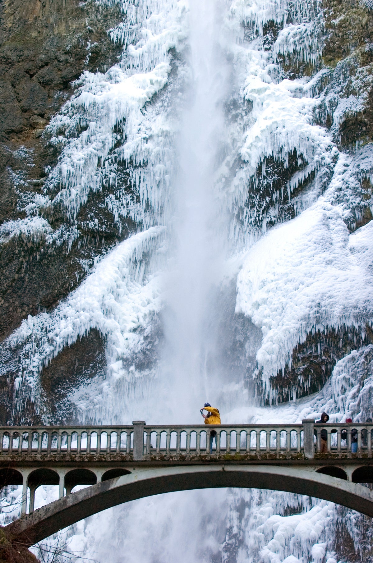 Todd Rua from Clackamas takes a photo of iced up Multnomah Falls Wednesday morning. Sightseers and photographers were out taking photos of iced up waterfalls in the Columbia River Gorge before bad weather moves in later this week