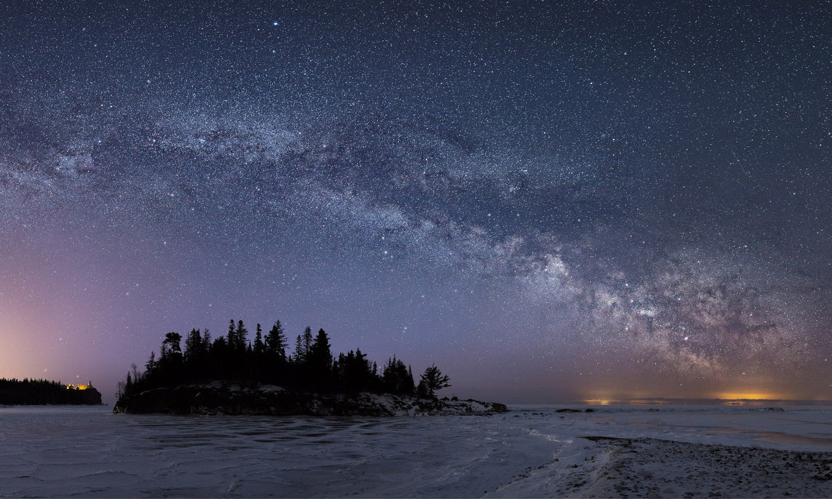 The Milky Way shines brightly over Ellingson Island at Splitrock Lighthouse State Park south of Beaver Bay during an early 20 below zero morning along Minnesota's north shore of Lake Superior. Comprised of 7 vertical photos blended together to form the final result seen here. Photograph by Beau Liddell