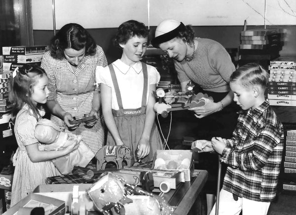 Susan Comrie, Mrs. W.A. Comrie, Joey Day, Mrs. P.H. Hulley and John Day inspect some of the exciting wares at the toy shop being conducted during holiday season at 2074 W. Burnside street by mothers of children in junior boys and girls choir of Trinity Episcopal church. Courtesy The Oregonian