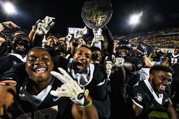 UCF players hold up the War on I4 trophy after winning against USF at Spectrum Stadium on Nov. 24, 2017. UCF won 49-42. Aileen Perilla / Orlando Sentinel