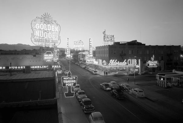 View of Fremont Street at dusk, including signs for the Golden Nugget, Hotel Apache, Pioneer Club, Boulder Club and Las Vegas Club, circa 1950. Courtesy MANIS COLLECTION, UNLV University Libraries Special Collections & Archives