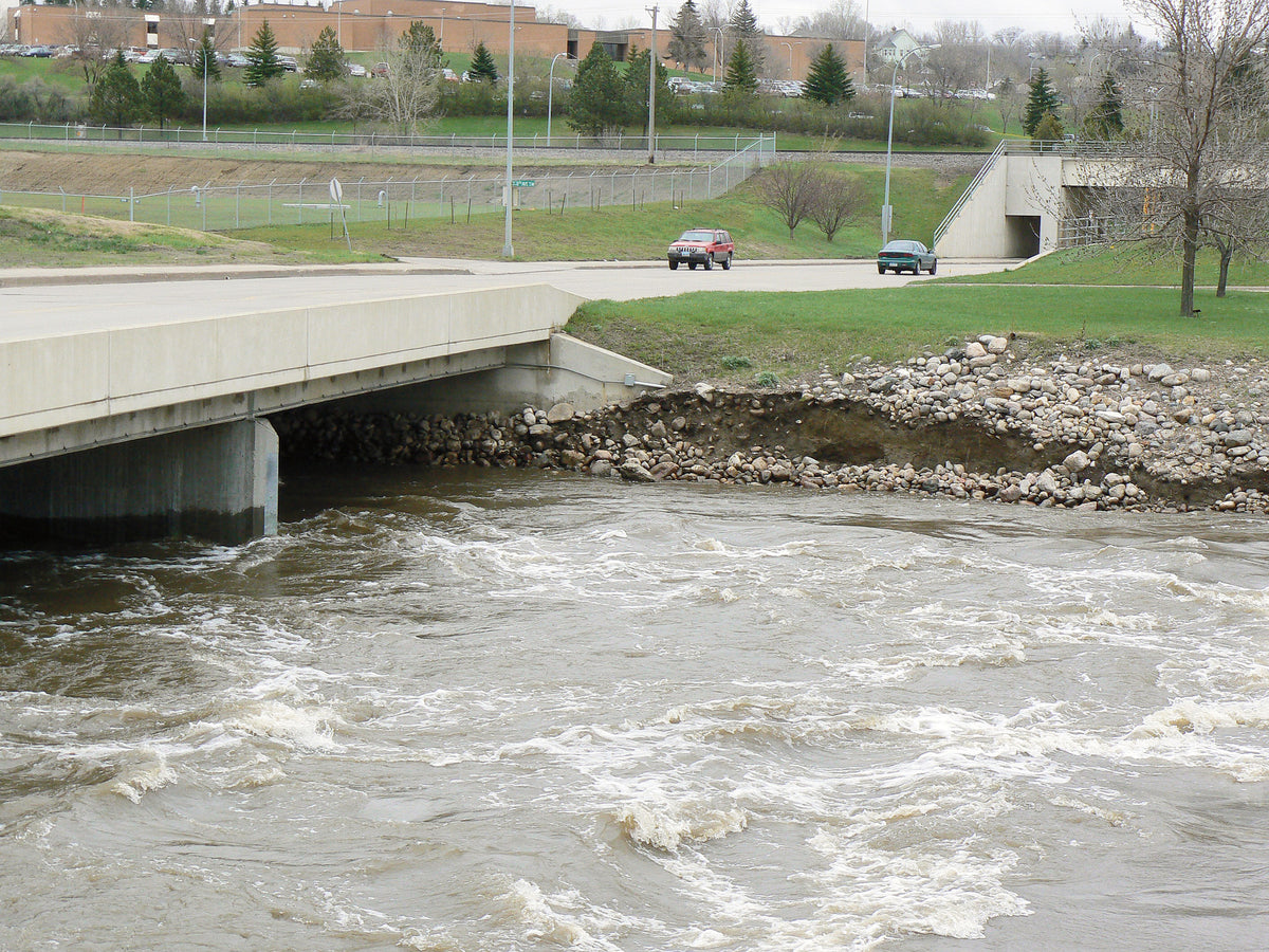 Souris River water churns against the bank and bridge near Minot's water treatment plant on May 11.